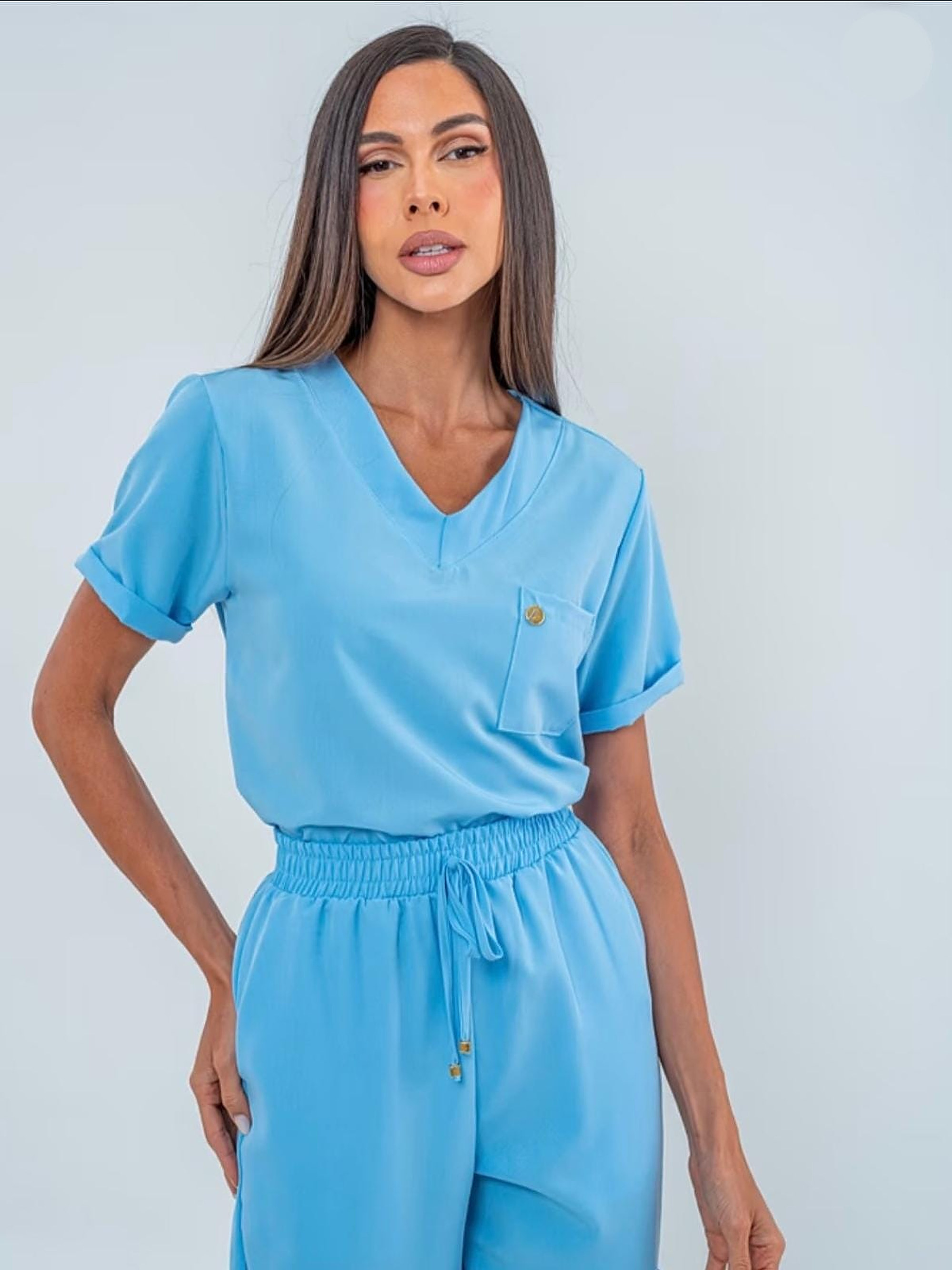 Scrub Madame Azul Sereno — detalhe do decote V e bolso frontal